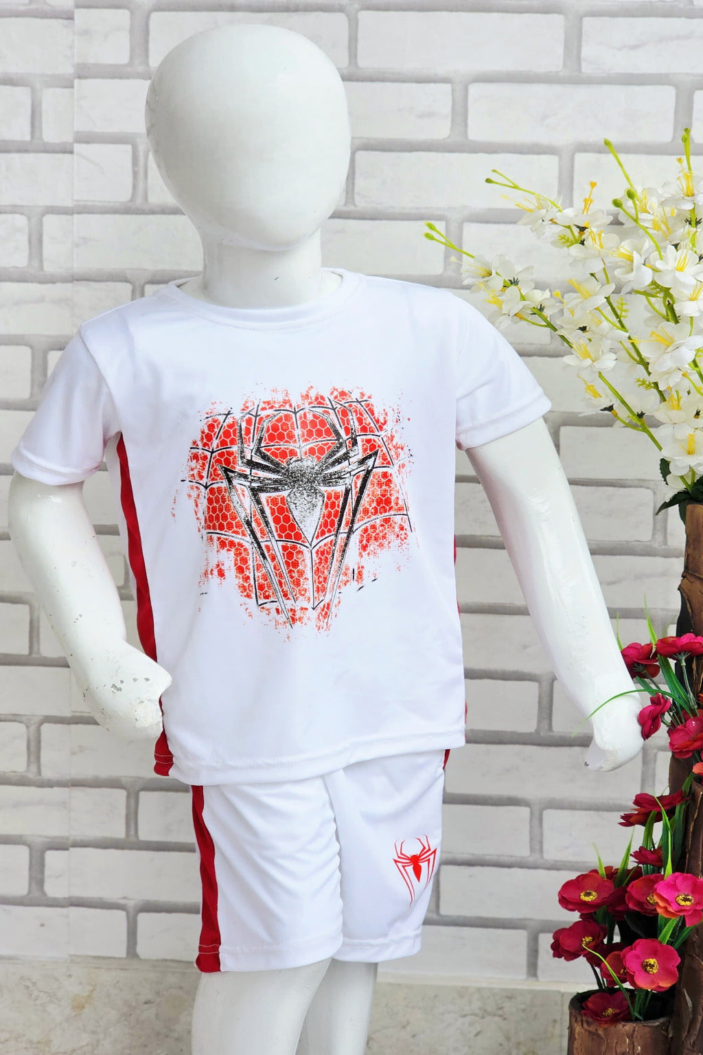 Mannequin wearing a white outfit with red accents against a brick wall.