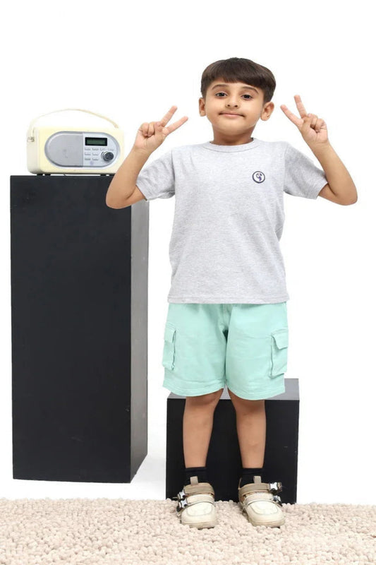 Child standing next to a black and gray electronic device on a white background