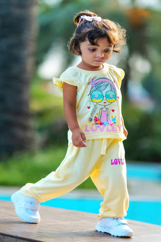 Child wearing a yellow outfit with a cartoon design by a poolside