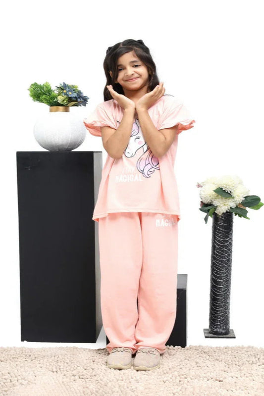 Child in pink outfit standing in front of decorative plants on a white background