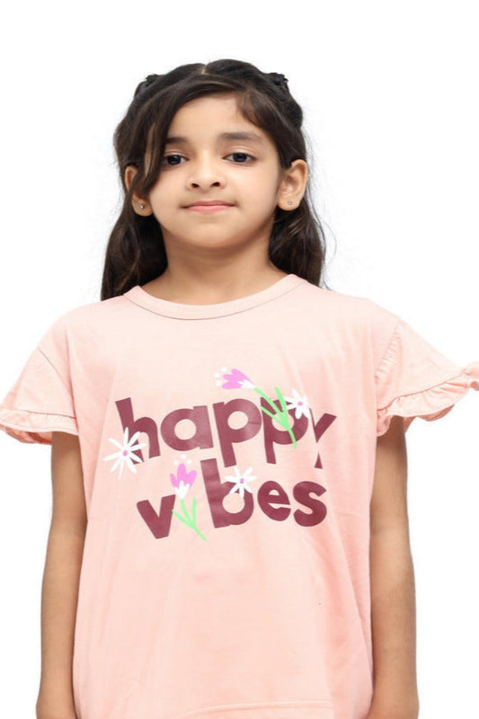 Young girl wearing a pink 'happy vibes' t-shirt on a white background