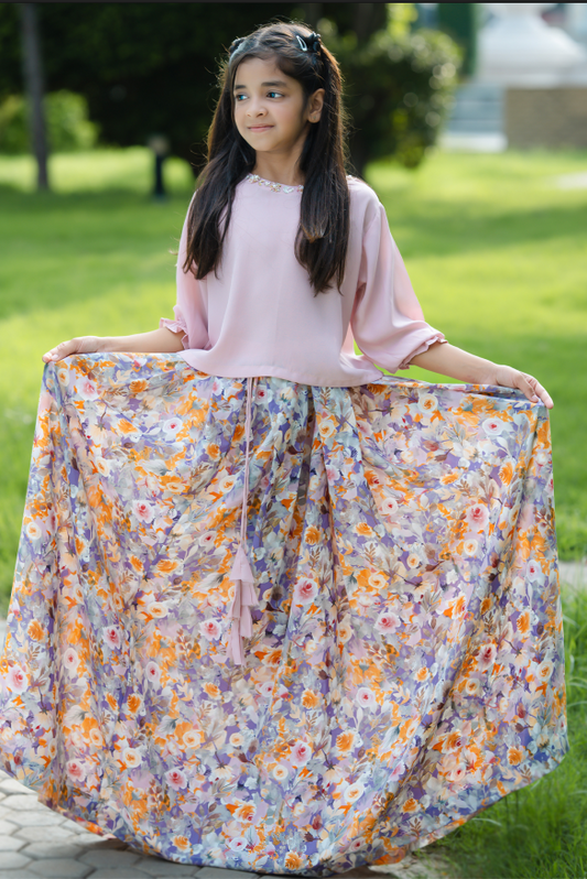 Young girl holding a floral skirt outdoors on a grassy area