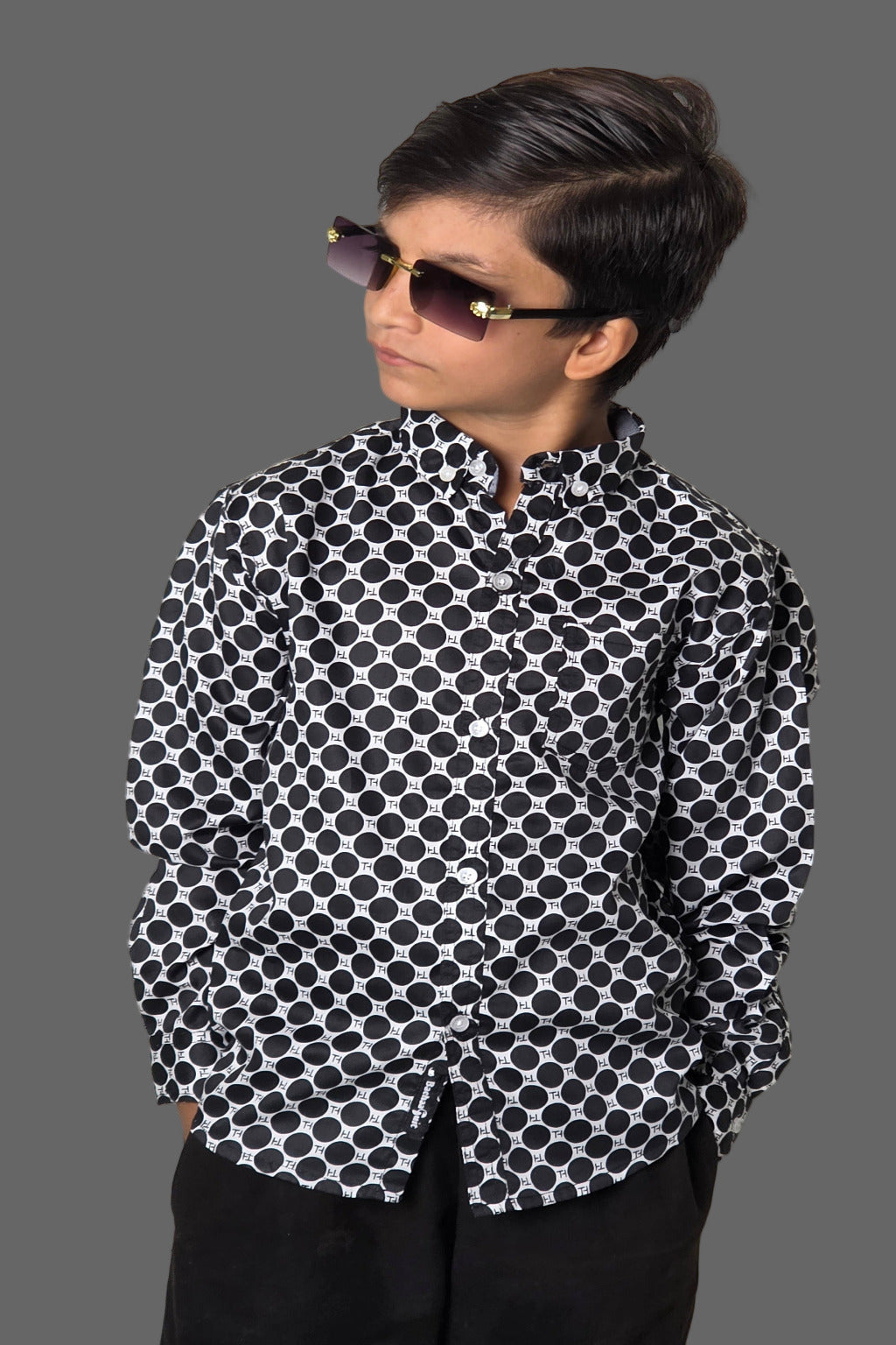 Person wearing a black and white patterned shirt against a plain background