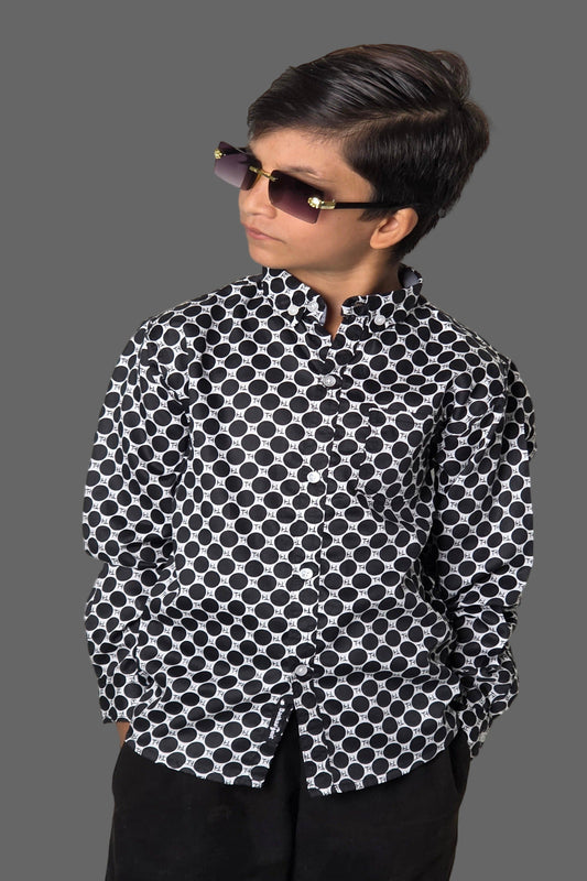 Person wearing a black and white patterned shirt against a plain background
