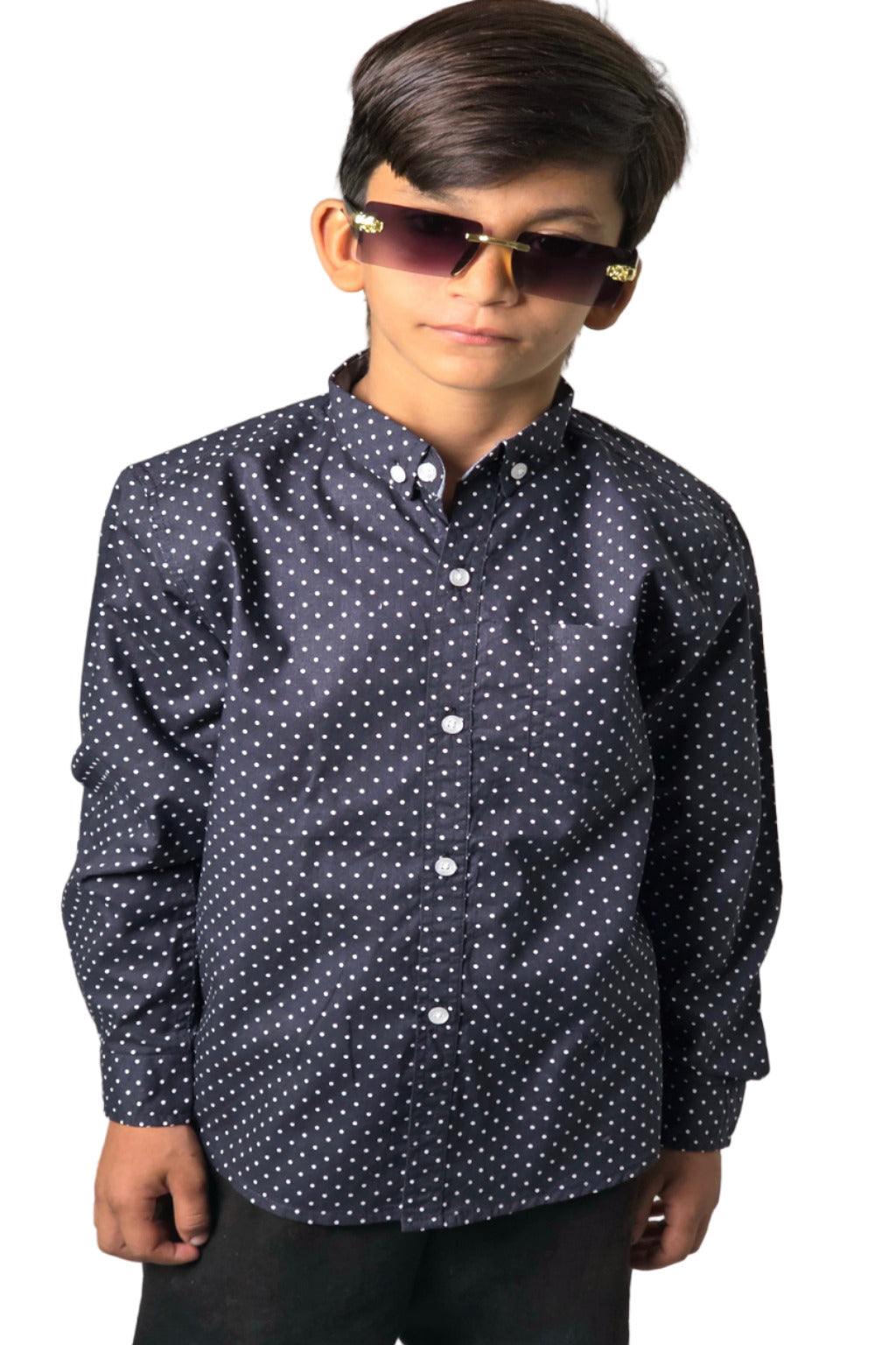 Child wearing a dark shirt with white polka dots and sunglasses on a light gray background