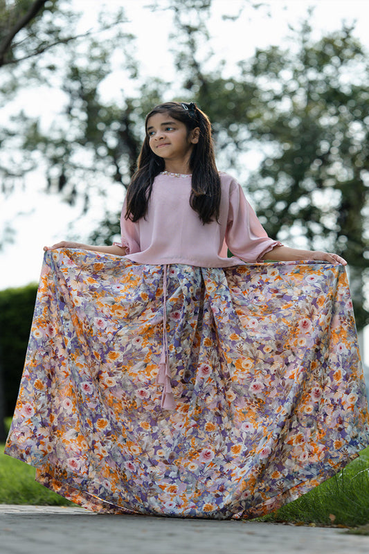 Young girl holding a floral skirt outdoors with trees in the background