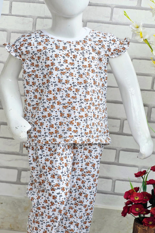 Floral pajama set on a mannequin against a brick wall background
