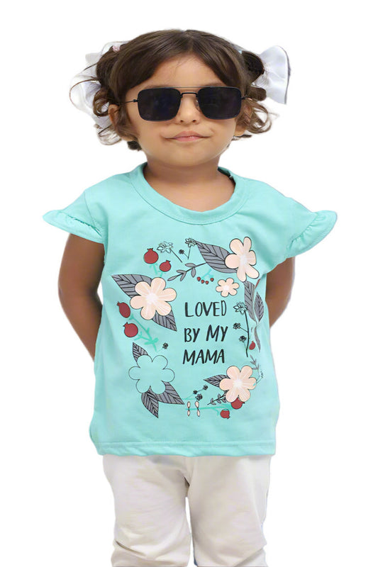 Child wearing a turquoise t-shirt with floral design and text, standing on a black block against a white background.
