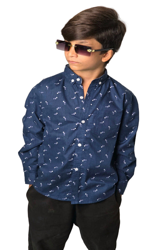 Child wearing a blue patterned shirt and sunglasses against a plain background