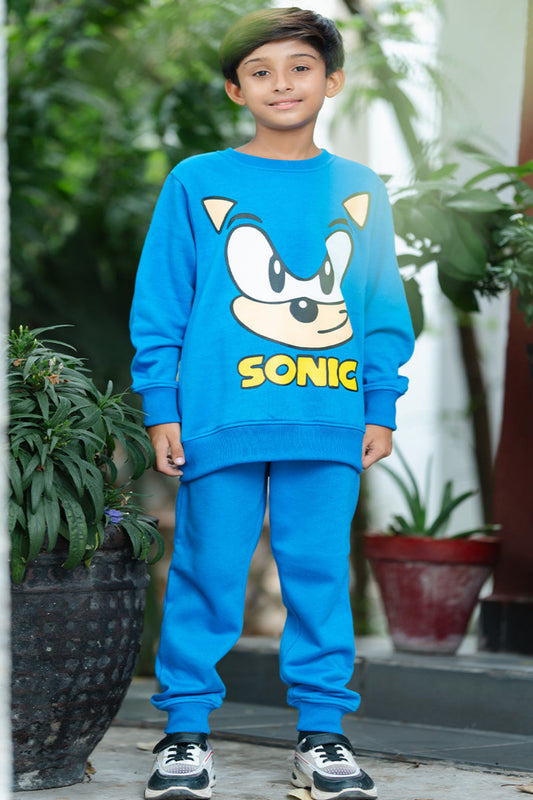 Child wearing a blue Sonic the Hedgehog outfit standing outdoors.